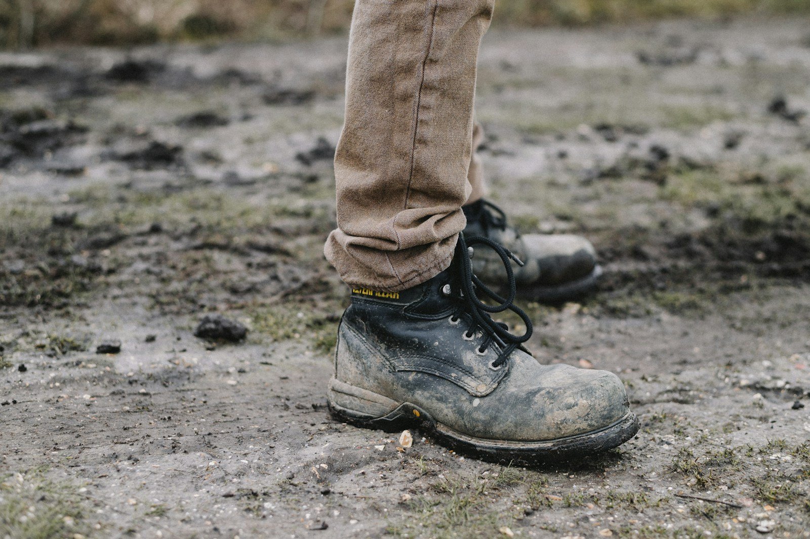 A muddy hiking boot on a stony path.