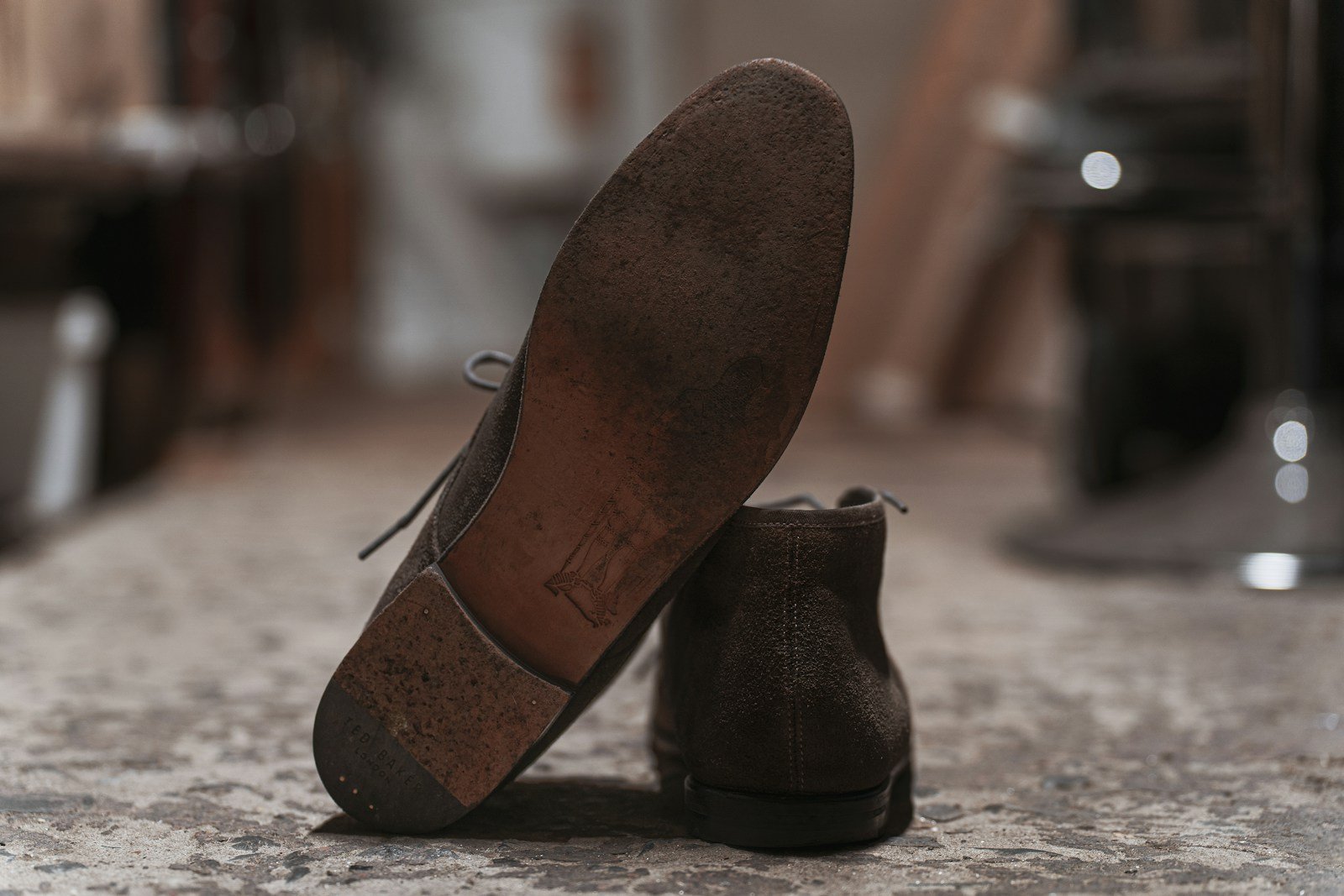 A worn leather boot sole leaning against another boot.