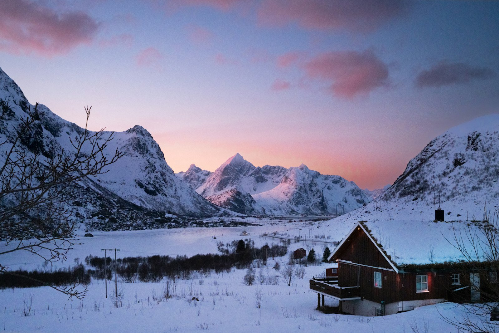 A red Norwegian mountain cabin in alpine terrain.
