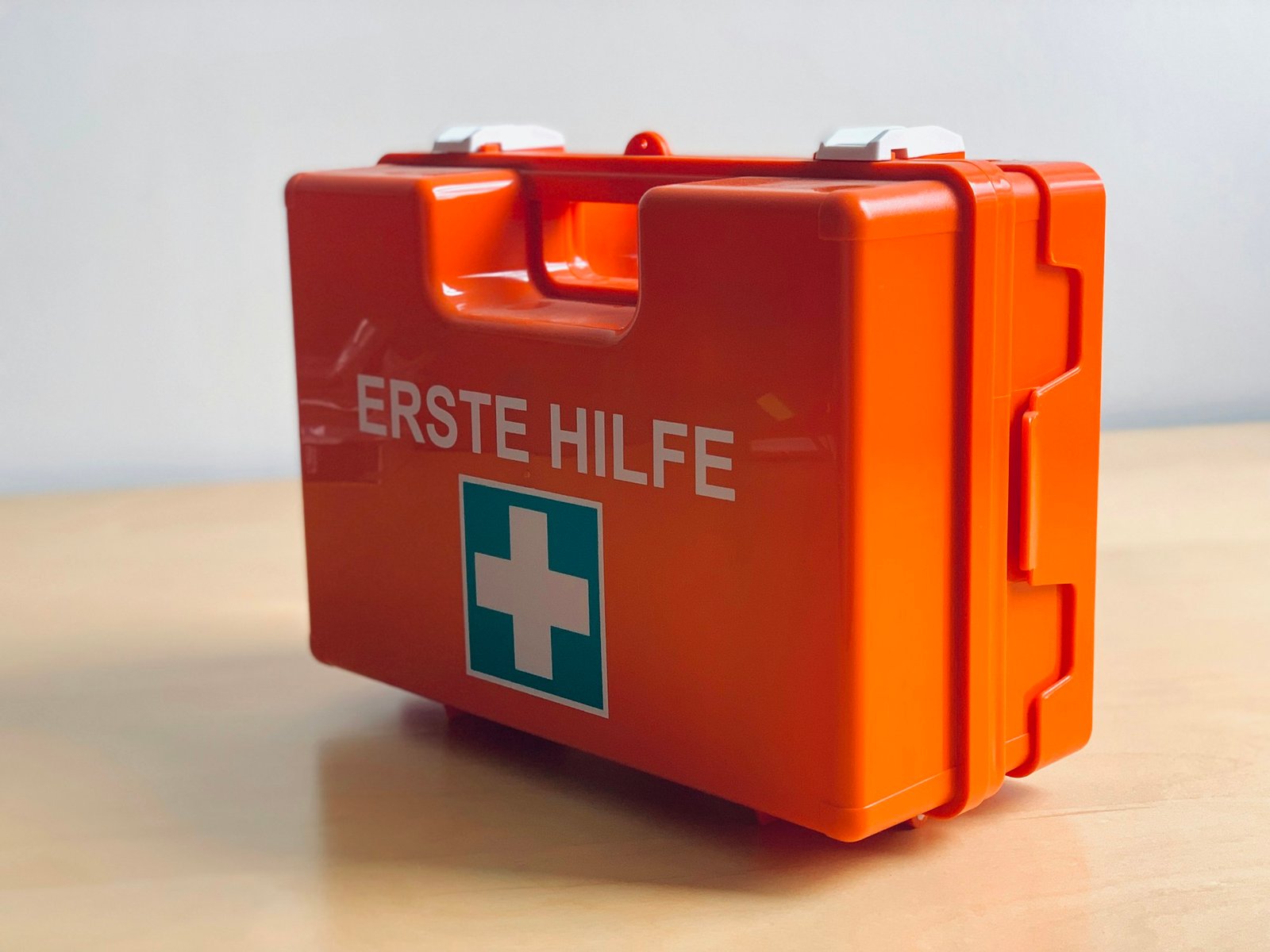 Orange first aid kit open, showing medical supplies inside.