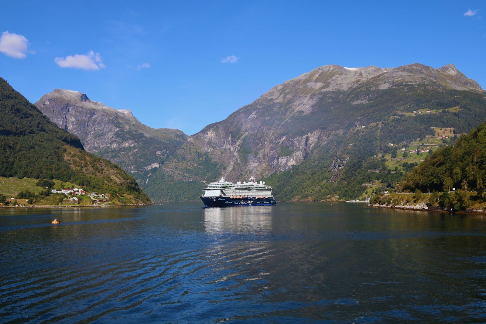 A boat approaches the cliffs of the Lysefjord under Preikestolen.