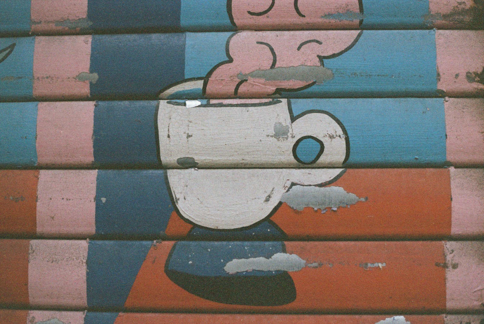 Mural of a steaming cup of coffee on a shutter.