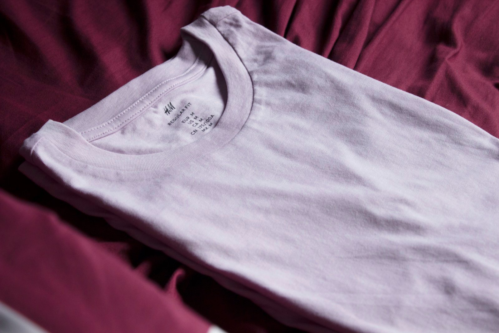 A folded cotton T-shirt in soft natural light.