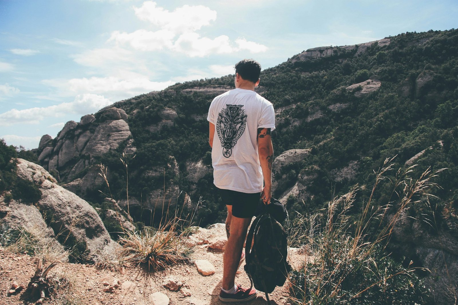A hiker on the trail in a casual T-shirt and pack.